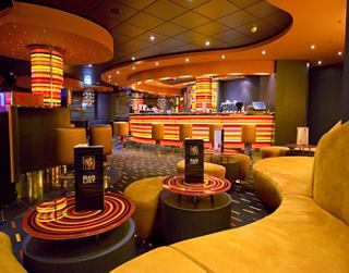 Bar moderne avec une atmosphère chaleureuse et des couleurs vives, idéal pour se retrouver | MSC Croisières