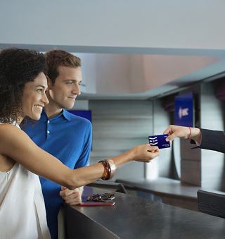 Ein Paar genießt sein Erlebnis, während es am Servicetresen seine Voyager-Karte erhält | MSC Cruises