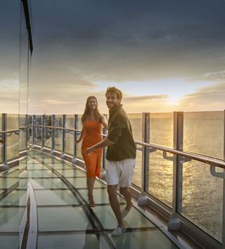 Mujer mirando la puesta de sol desde la cubierta de un crucero | MSC Cruises