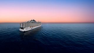 A ship sails on calm waters, illuminated by soft sunset colors | MSC Cruises