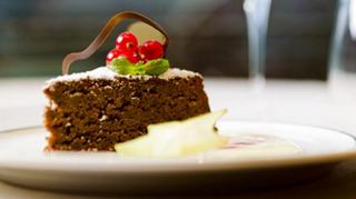 Une part de gâteau au chocolat avec de la crème et une cerise dans une assiette | MSC Croisières