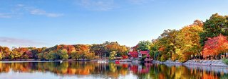 A serene lake reflects the vibrant colors of autumn foliage surrounding it | MSC Cruises