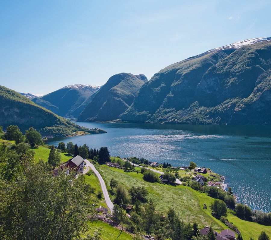 Ruhiger See, umgeben von majestätischen Bergen und üppigem Grün | MSC Cruises