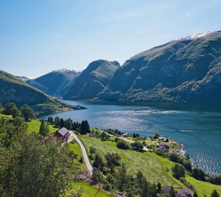 Ruhiger See, umgeben von majestätischen Bergen und üppigem Grün | MSC Cruises