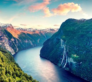 Breathtaking view of a fjord surrounded by mountains and a river in the valley | MSC Cruises
