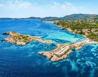 Crystal clear waters surround a picturesque coastline with lush green hills | MSC Cruises