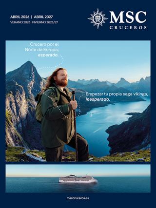 Una persona está en la cima de una montaña, disfrutando de la vista de un lago y montañas | MSC Cruceros