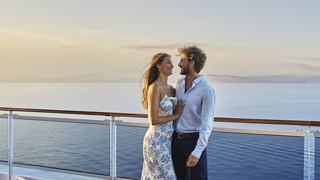 Paar genießt Meeresbrise auf dem Deck eines Kreuzfahrtschiffs | MSC Cruises