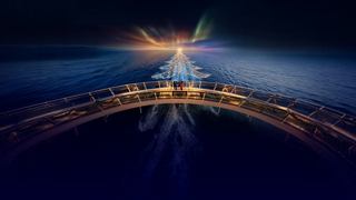 A Christmas tree with sparkling lights shines on the deck of a cruise ship at night | MSC Cruises