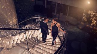 Dos personas en una escalera brillante rodeadas de luces festivas y ambiente cálido | MSC Cruises