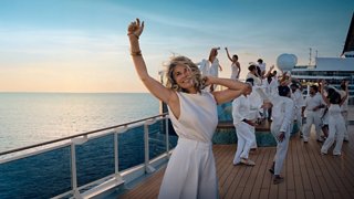 Un groupe de personnes célèbre sur le pont d’un navire de croisière au coucher du soleil | MSC Croisières
