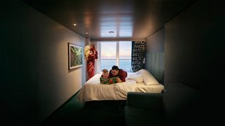 A family enjoys breakfast in a cabin with a balcony overlooking the sea and sunrise | MSC Cruises