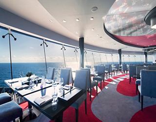 Restaurant moderne avec fenêtres panoramiques et sièges confortables, offrant une vue imprenable sur la mer | MSC Croisières