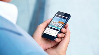Un uomo che utilizza un telefono cellulare per gestire la propria prenotazione ed esplorare opzioni di viaggio | MSC Crociere