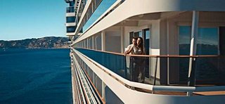 A guest enjoys the view from a balcony on a cruise ship overlooking the blue sea | MSC Cruises