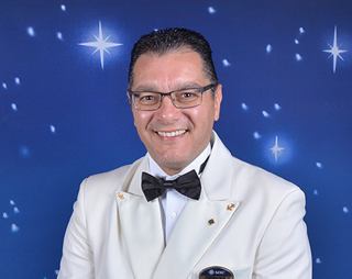 Captain Domenico Calise smiling against a blue starry background | MSC Cruises