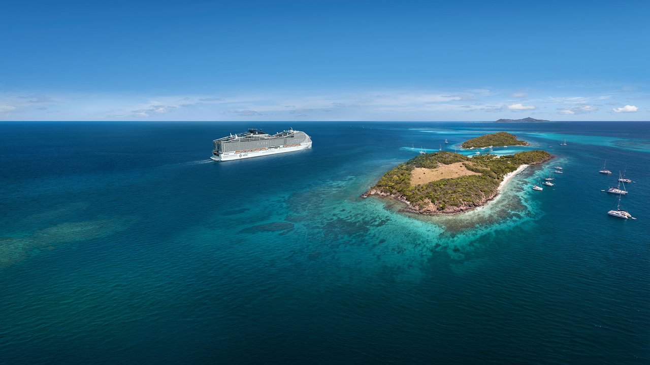 Kreuzfahrtschiff fährt auf blauem Ozean zu tropischen Inseln mit weißen Stränden | MSC Cruises