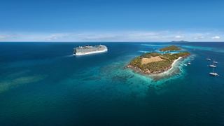 Navire de croisière naviguant sur un océan bleu vers des îles tropicales aux plages blanches | MSC Croisières