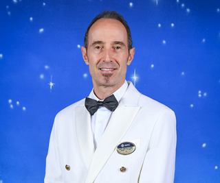 Capitano in uniforme bianca con sfondo stellato | MSC Cruises