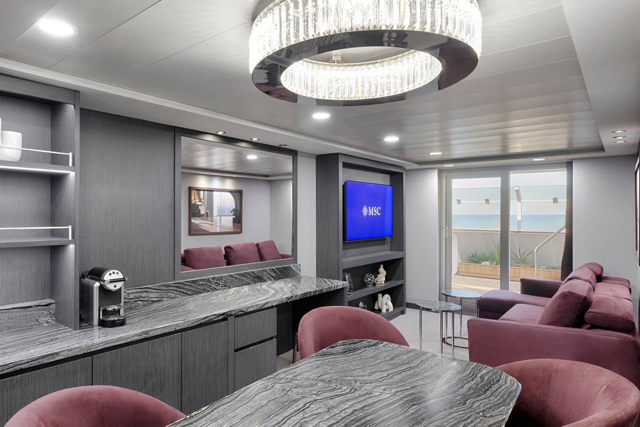 Luxurious yacht club interior featuring elegant furniture and a modern television | MSC Cruises