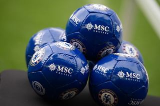 Four blue footballs grouped together on the field, ready for the game | MSC Cruises