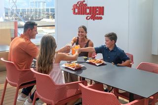 A group of people enjoy a meal together in a welcoming setting aboard a cruise ship | MSC Cruises