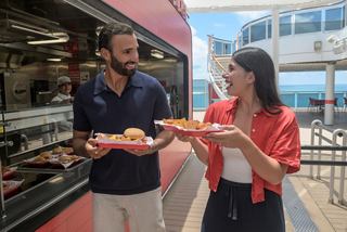 Two people enjoy freshly prepared food outdoors by a restaurant on a cruise ship | MSC Cruises