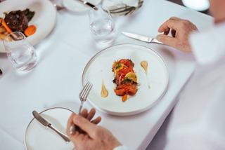 A refined salmon fillet with garden vegetables presented in a stylish cruise restaurant setting | MSC Cruises
