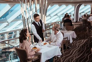 Guests enjoy attentive service in a refined restaurant with panoramic sea views | MSC Cruises