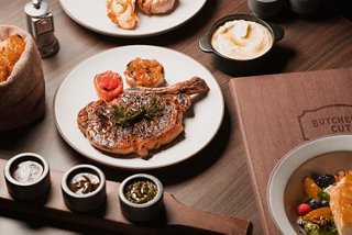 An entree with sides and sauces presented on a table for a gourmet dining experience | MSC Cruises