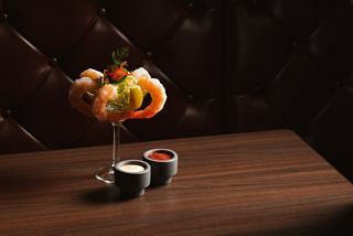 Shrimp cocktail and sushi on a wooden table in a warm and inviting setting | MSC Cruises