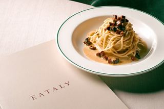 A serving of pasta with sauce and a menu placed on a table in a welcoming setting | MSC Cruises