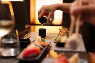 Sushi rolls and sake are served at a stylish table in a welcoming atmosphere | MSC Cruises
