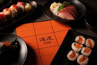 A selection of sushi and sashimi served with a menu and soy sauce on the table | MSC Cruises