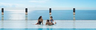 Familien genießen den ruhigen Gartenpool auf der MSC Preziosa, mit einem atemberaubenden Meerblick im Hintergrund | MSC Cruises