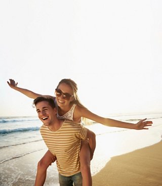 Un couple profite joyeusement de leur temps ensemble sur la plage, embrassant l'amour et l'aventure | MSC Cruises
