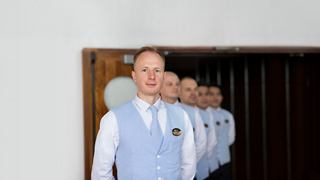Ein Besatzungsmitglied grüßt herzlich in einer einladenden Umgebung und zeigt Hingabe und Service | MSC Cruises