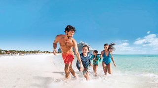 Una familia disfruta de un día en una playa de arena blanca bajo un cielo azul | MSC Cruises