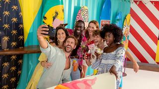 A joyful group of friends celebrating together with vibrant flags in the background, capturing a moment of togetherness | MSC Cruises