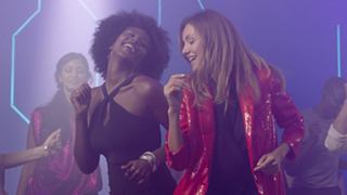 Two performers joyfully singing together on stage, creating an uplifting atmosphere for the audience | MSC Cruises
