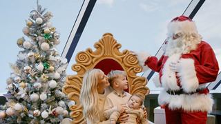 A decorated Christmas tree beside a person in red attire and a golden throne | MSC Cruises