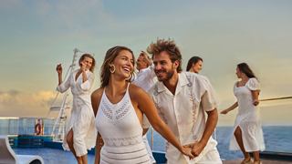 A joyful group of friends enjoying a sunset celebration together on a cruise deck | MSC Cruises