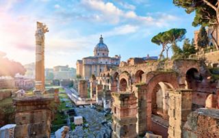 A stunning view of the ancient Roman Forum with historical buildings and the Church of Saint Luca and Martina in the background | MSC Cruises