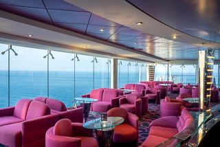 Modern seating area with pink sofas and panoramic sea views | MSC Cruises