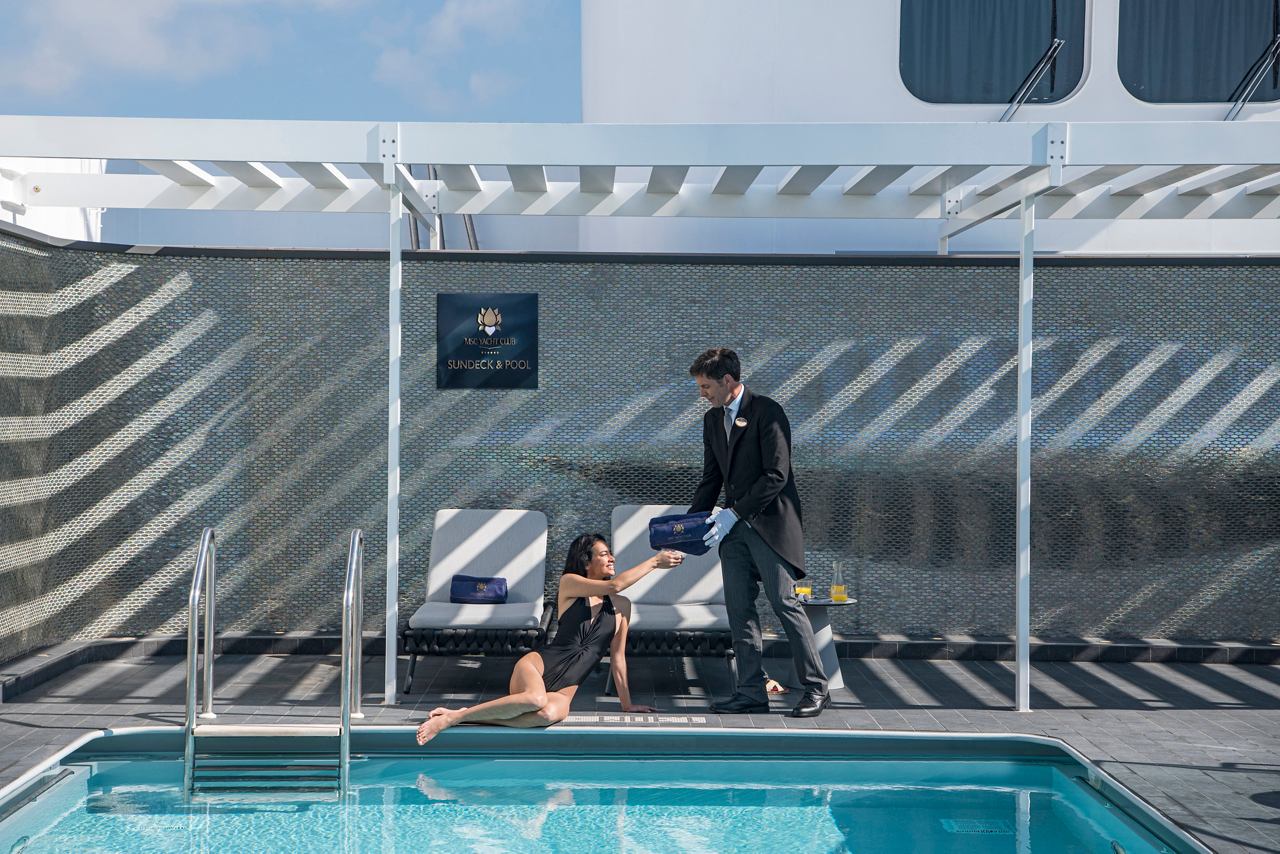 Frau genießt ein Getränk in der Sonne am Pool des MSC Yacht Club | MSC Cruises