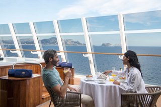 Ein Paar genießt das Frühstück auf einer Terrasse mit Meerblick | MSC Cruises