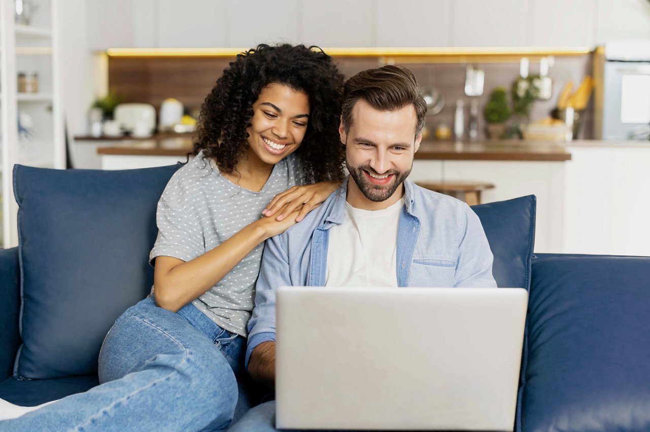 A couple enjoys time together while browsing on a laptop at home | MSC Croisières