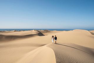 Une personne marche sur des dunes de sable face à la mer sous un ciel bleu | MSC Croisières