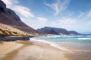 A serene beach scene at Baia das Gatas, showcasing mountains and a calm sea under a clear sky | MSC Cruises