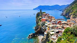 Un village côtier pittoresque niché entre des falaises et la mer, présentant des bâtiments colorés le long de la côte | MSC Croisières